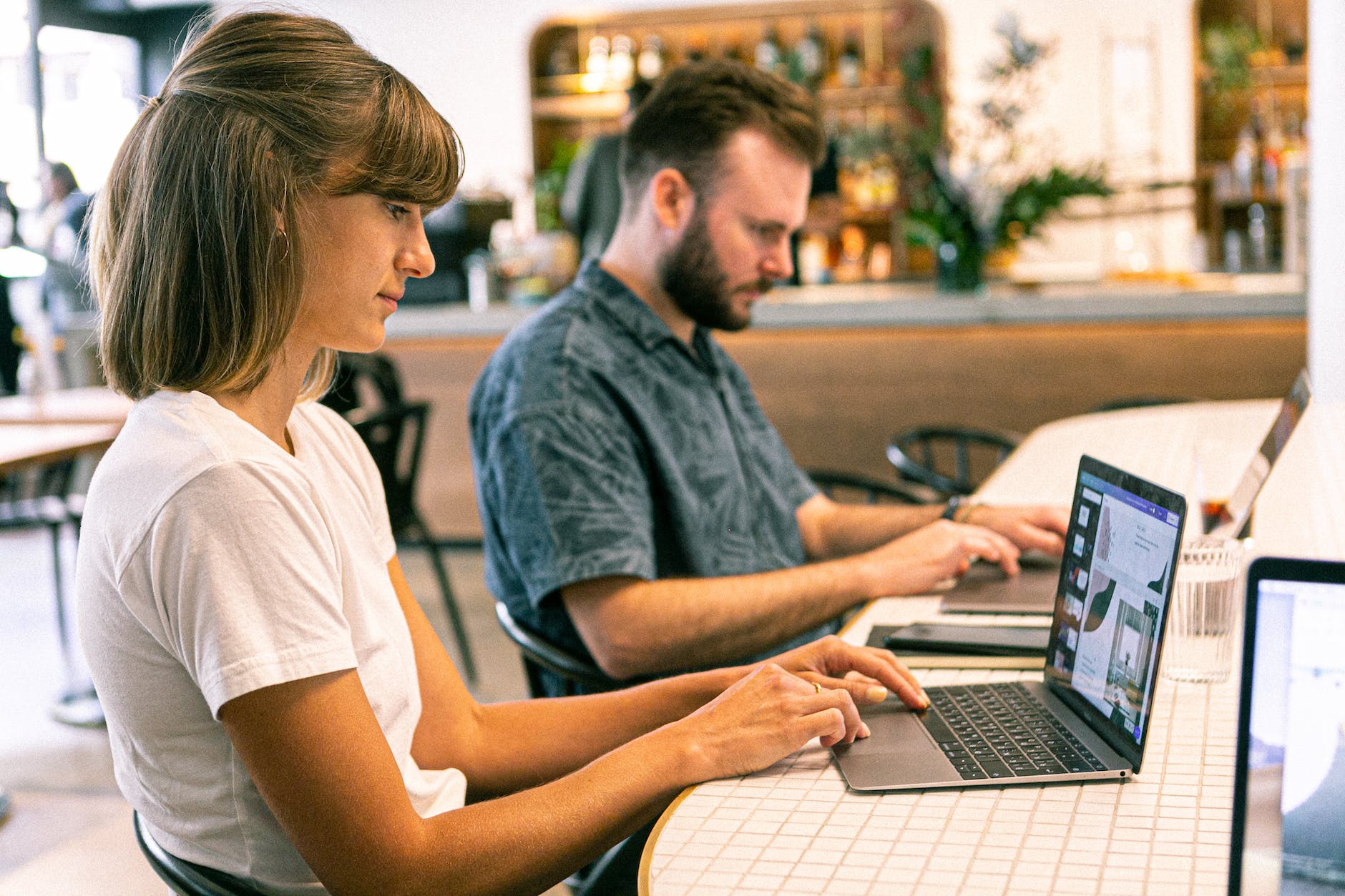 photo of man and woman using laptop